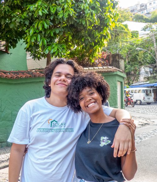 EduMais student Wesley and friend smile outside Solar Meninos de Luz