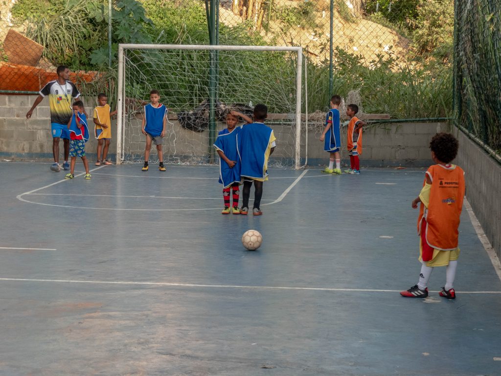 Student on EduMais's Education-Based Football Program gets ready to take a free kick on the pitch in Cantagalo