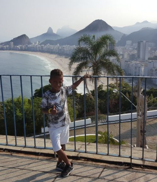 EduMais After-School Program student Renee at Leme fort with view of Copacabana and Rio de Janeiro's hills in the background