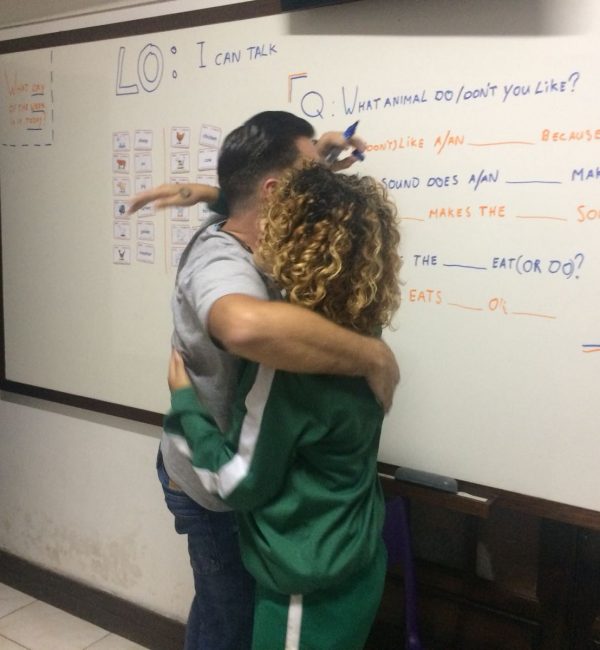 EduMais volunteer English teacher Daan receives a warm hug from one of his students in the classroom