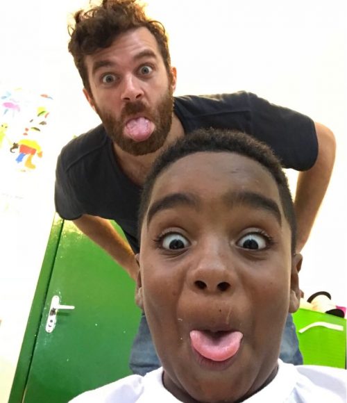 Volunteer Ed and after-school program student Andre take a selfie with their tongues sticking out