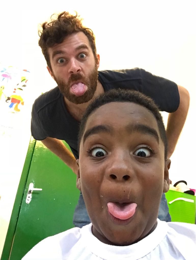 Volunteer Ed and after-school program student Andre take a selfie with their tongues sticking out