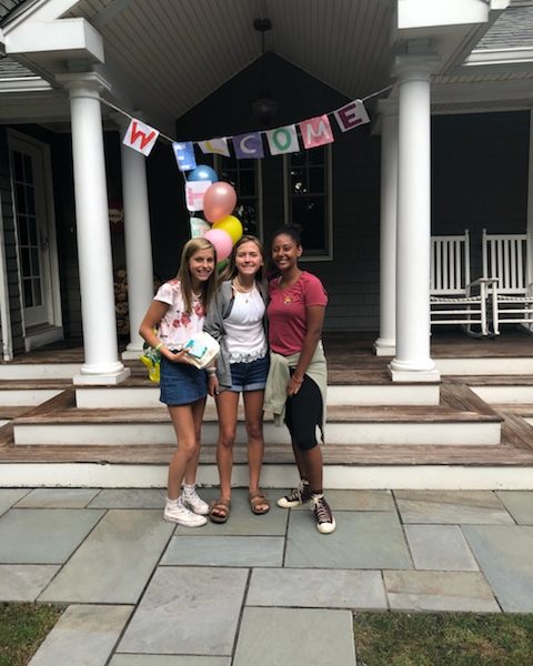 EduMais Exchange Student Thais at her host family's house with her host students and a big welcome sign