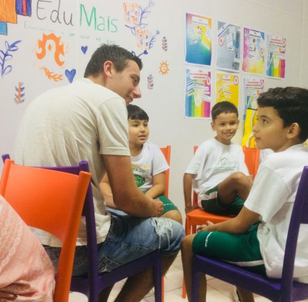 Volunteer English Teaching Assistant Hamish helps EduMais students with small group work in the English classroom