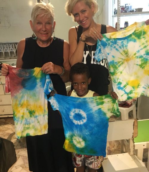 EduMais volunteer Hannah, her aunt, and one of the after-school boys pose with their tie-dye t-shirts