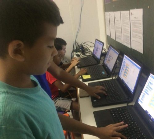 Children designing a game using Scratch on EduMais's Programming Summer Camp