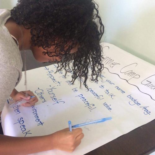 One girl student at EduMais's English Summer Camp 2019 signs the Summer Camp Guidelines sheet