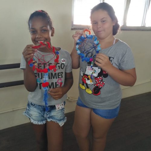 Two of EduMais's girl students display the dreamcatchers they made at EduMais's English Summer Camp 2019