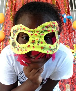 One of EduMais's Summer Camp students with a yellow mask over a lot of her face