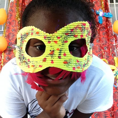 One of EduMais's Summer Camp students with a yellow mask over a lot of her face