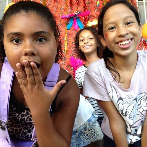 Three of EduMais's Summer Camp girls, two smiling, one with hand over her mouth as if in shock