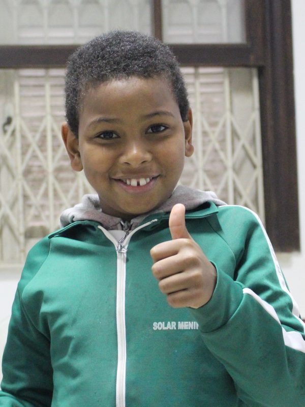 EduMais student gives a thumbs up and smile to the camera