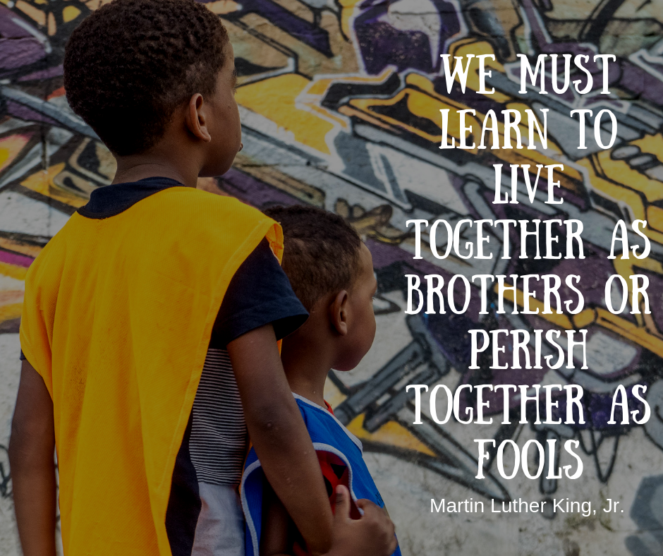 EduMais football student with arm around younger boy and Martin Luther King quote about need to learn to live together