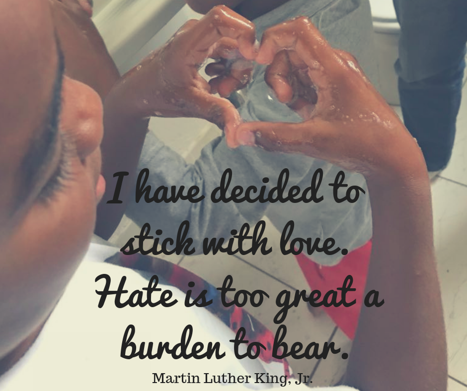 After-school student forms a heart with washing up liquid bubble in his hands and Martin Luther King Jr quote about love overlaid