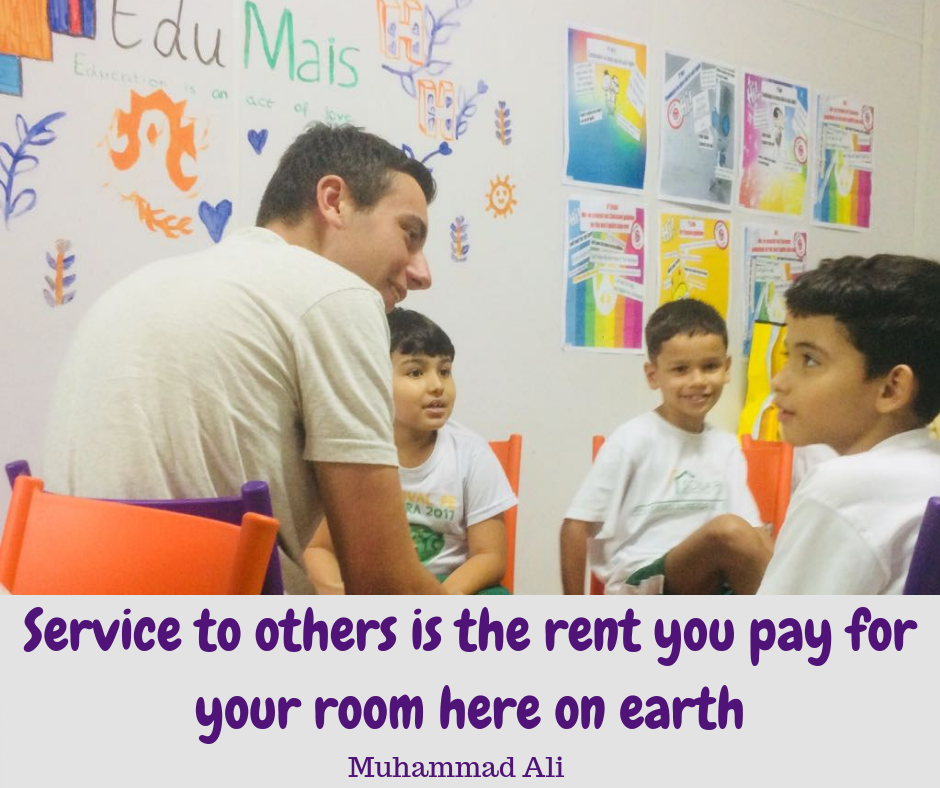 EduMais volunteer Hamish with EduMais students and Muhammad Ali quote about service to others