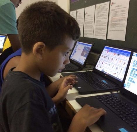 Boys on EduMais's Game Design Camp looking intently at their computers